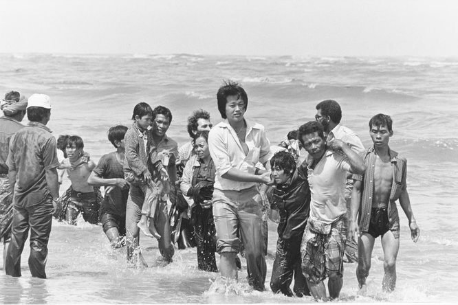 A group of Vietnamese refugees help carry each other to shore in Malaysia after their boat sank