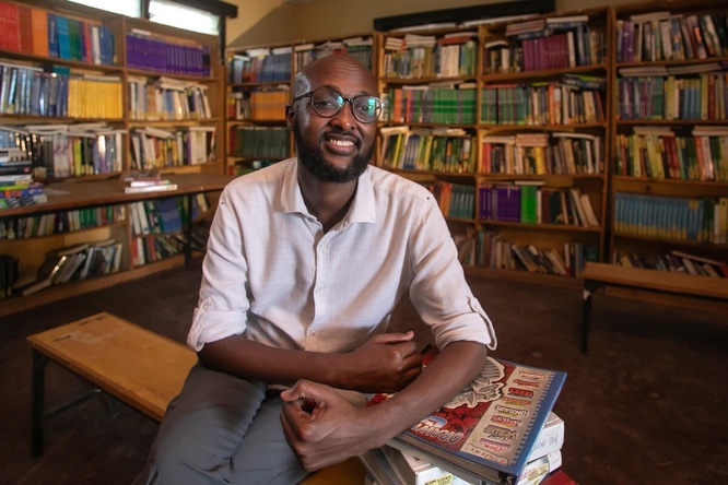 Abdullahi Mire sits smiling in a library