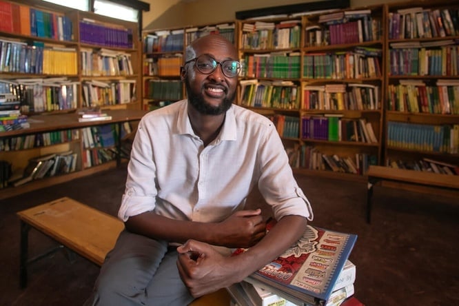 Abdullahi Mire sits smiling in a library