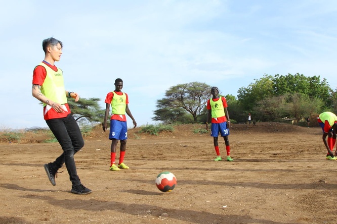 MIYAVI plays soccer (football) with refugees outside.
