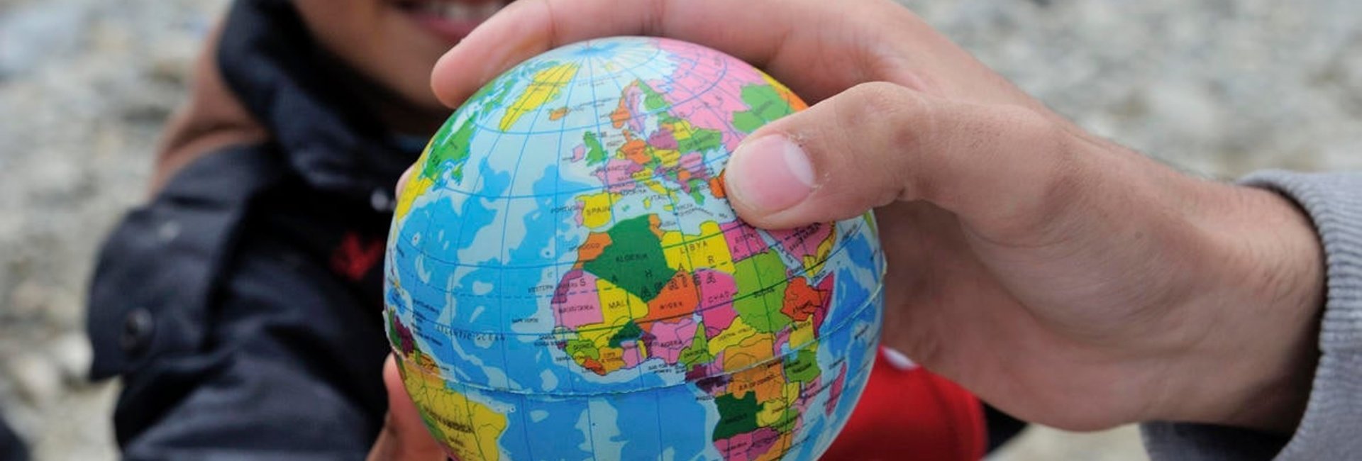 A young boy from Syria with a toy world globe, at the Vinojug Reception Centre just inside the Macedonian border from Greece.