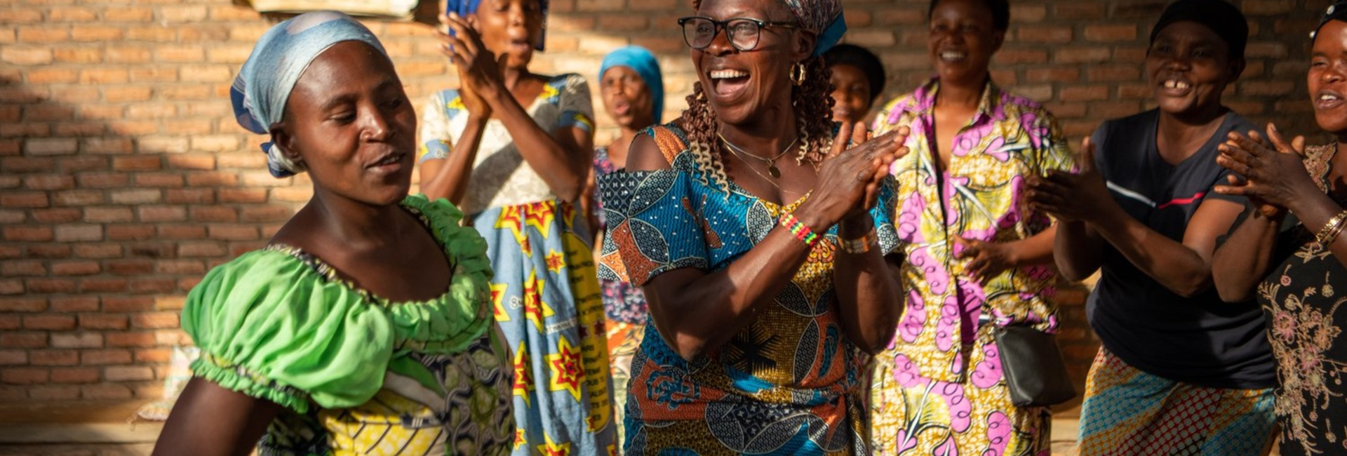 Women clap and dance together.