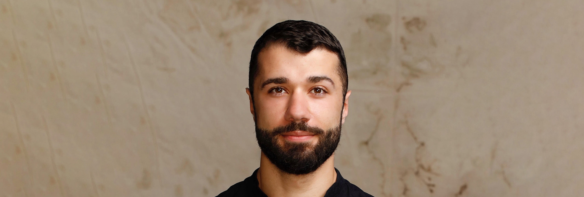 Ahmad Joudeh, High Profile Supporter for UNHCR, UN Refugee Agency looking at camera in a studio setting.