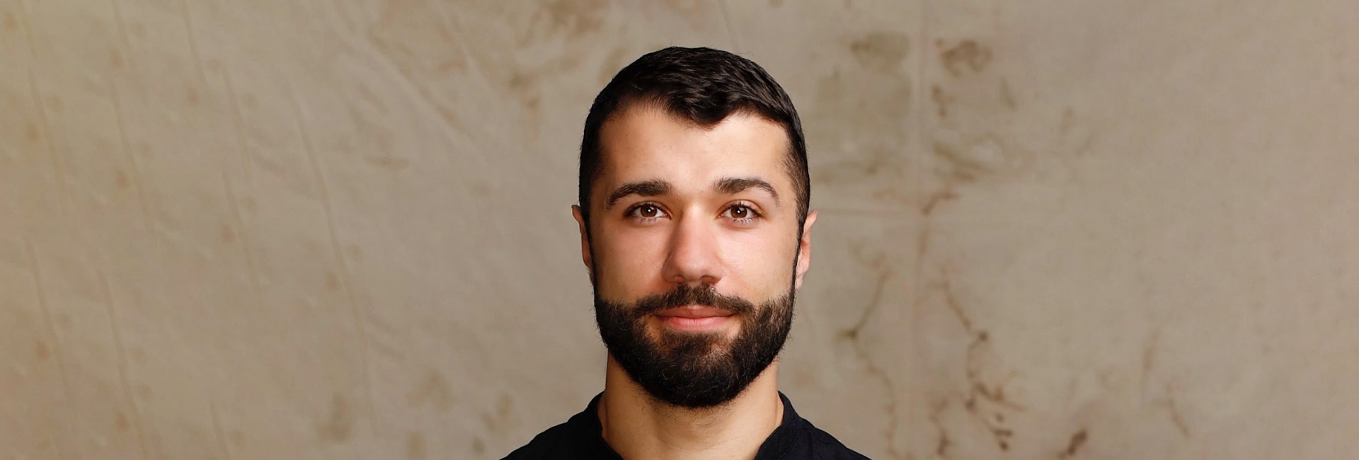 Ahmad Joudeh, High Profile Supporter for UNHCR, UN Refugee Agency looking at camera in a studio setting.