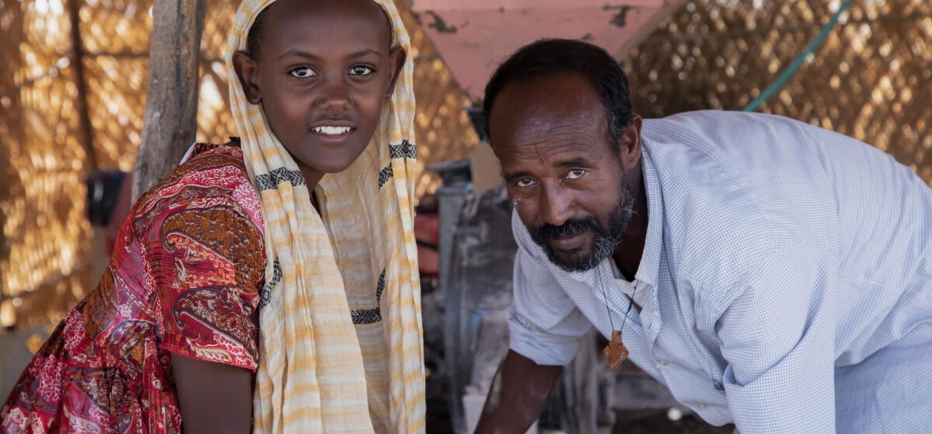 Ethiopian man stands next to a young Ethiopian girl.