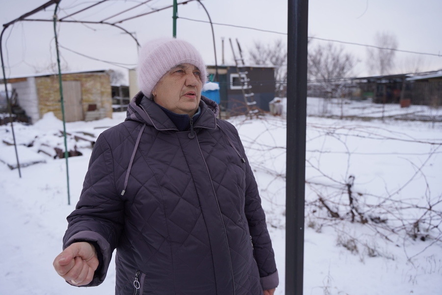 The space behind Valentyna is where her house once stood. It was razed to the ground by shelling at the start of the full-scale Russian invasion. Now, Valentyna and her husband who has disabilities are facing their second wartime winter living in a temporary modular house. 
