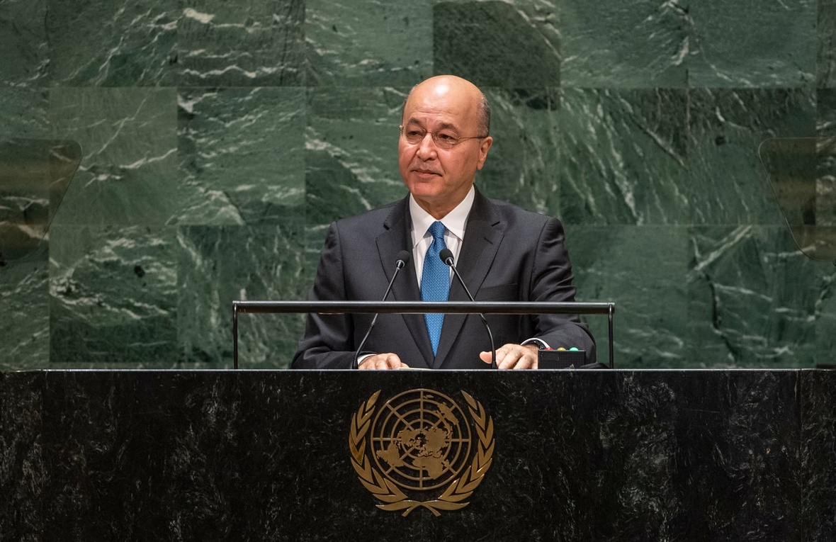 Barham Salih, wearing a suit, speaks at a podium bearing the United Nations emblem
