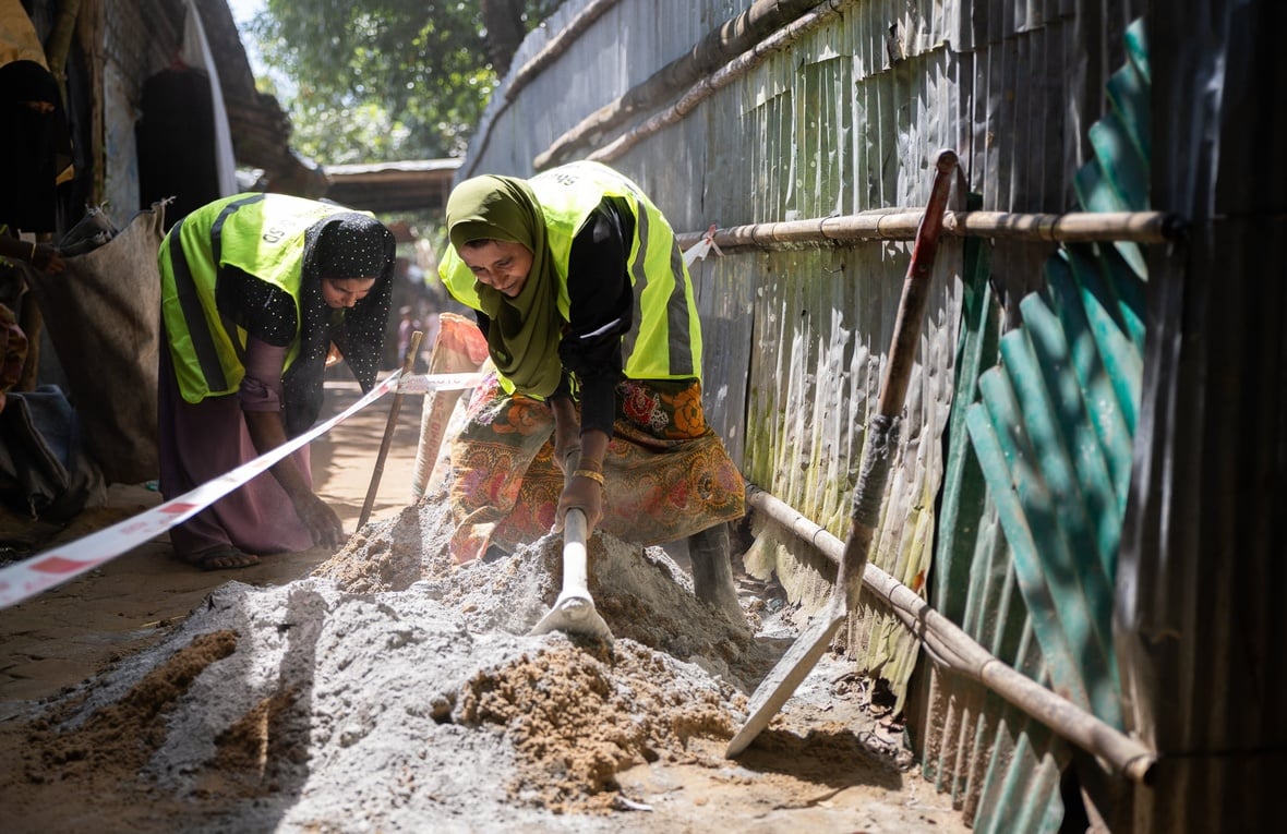 Rohingya refugee women in Cox's Bazar refugee camp working together to pave alleyways.