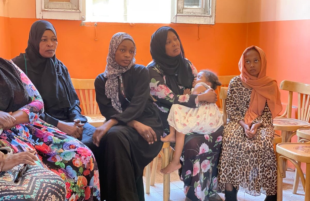 Sudanese women and children sit in a waiting room at Aswan train station.