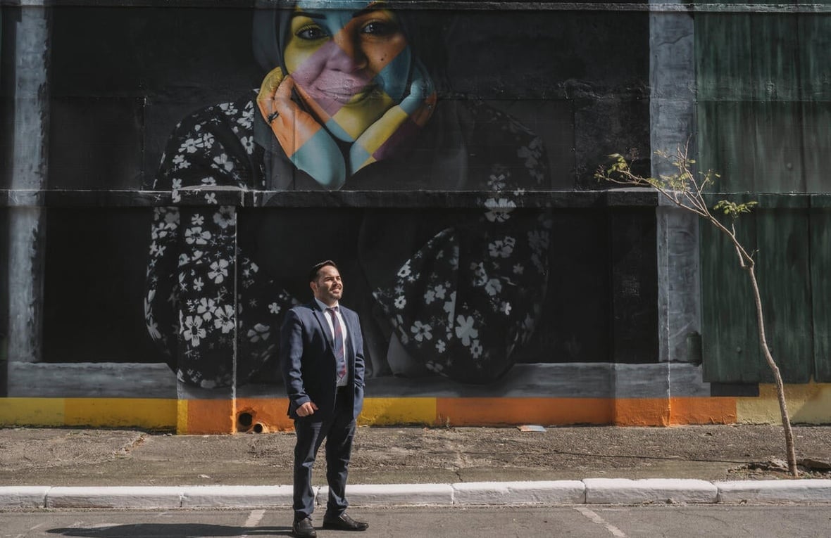 Abdul Jarour standing in front of a mural.