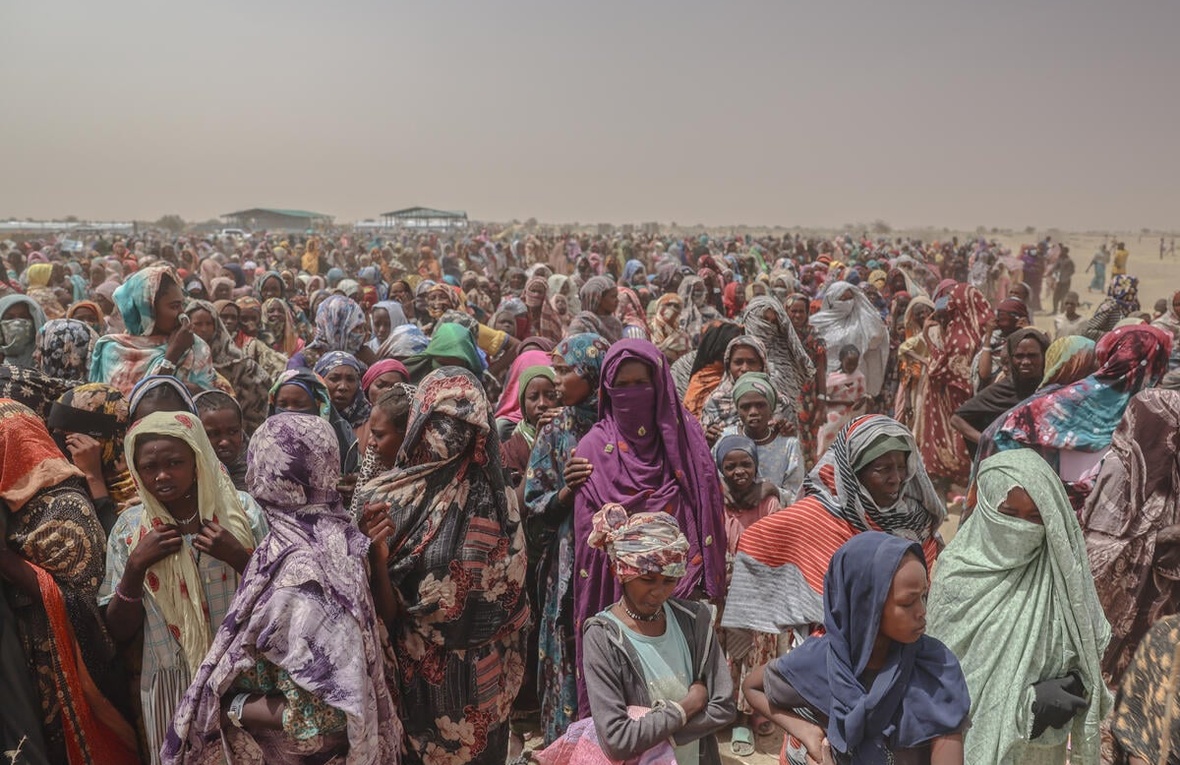 A huge crowd of refugees wait for food.