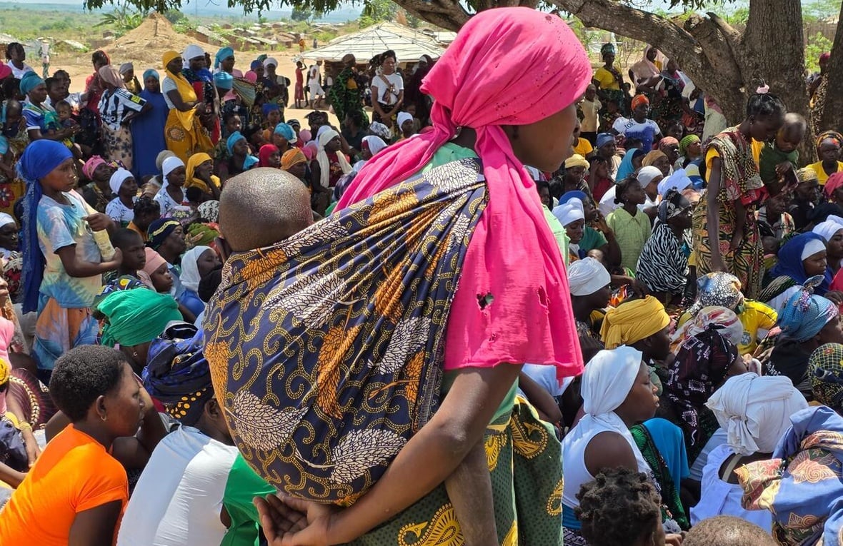 Huge groups of displaced families gather in the open under a large tree