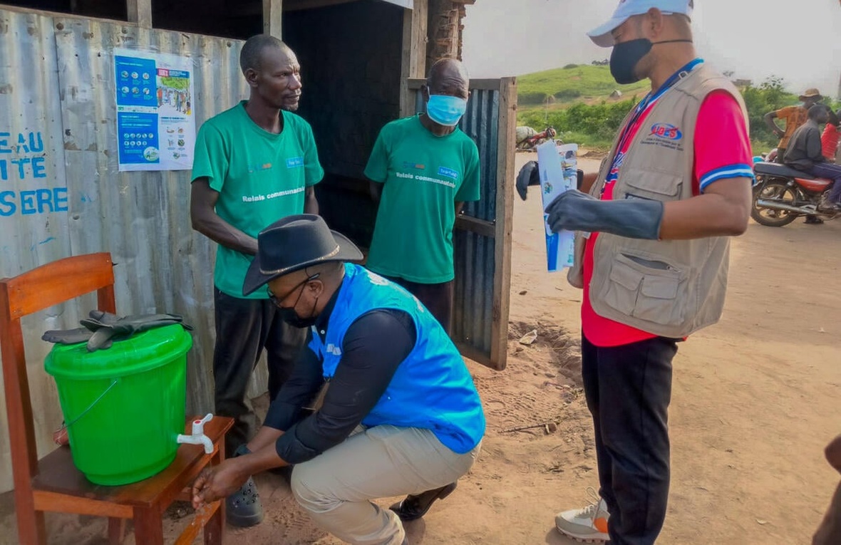 UNHCR staff inspect a chlorinated handwashing station