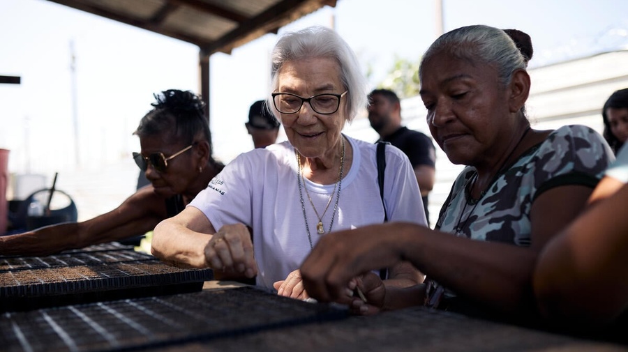 Sister Rosita Milesi sows seeds with refugee Mariela Josefina Astudillo
