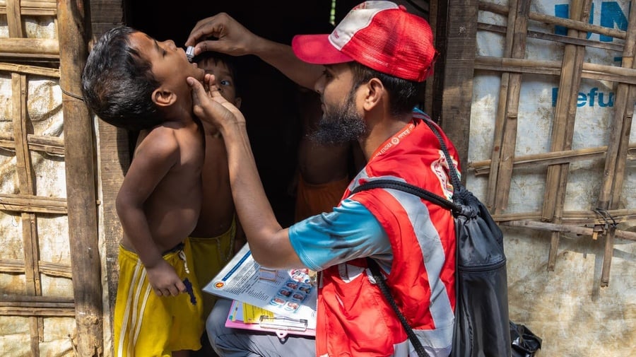 Bangladesh. A community health volunteer administers cholera medicine to a young child in the Rohingya refugee camps