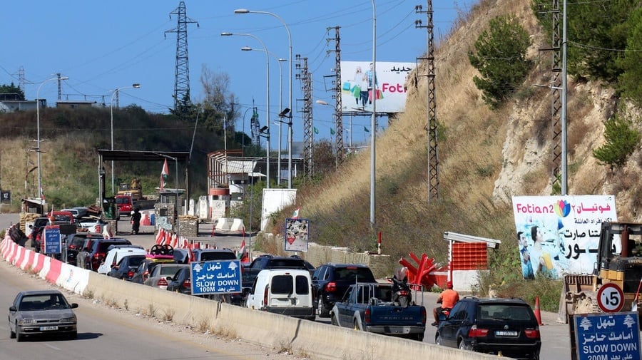 A line of cars waits to cross a checkpoint 