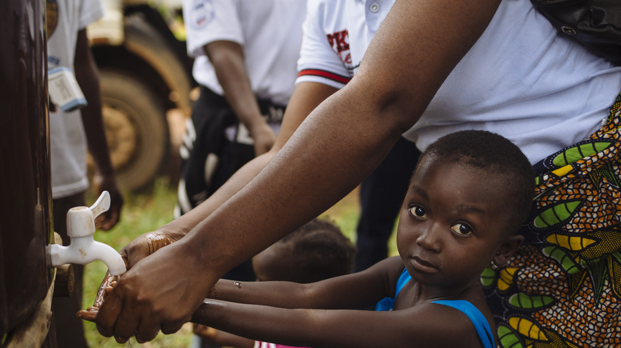 Liberia. Refugees queue for a health screening at the border with Côte d'Ivoire