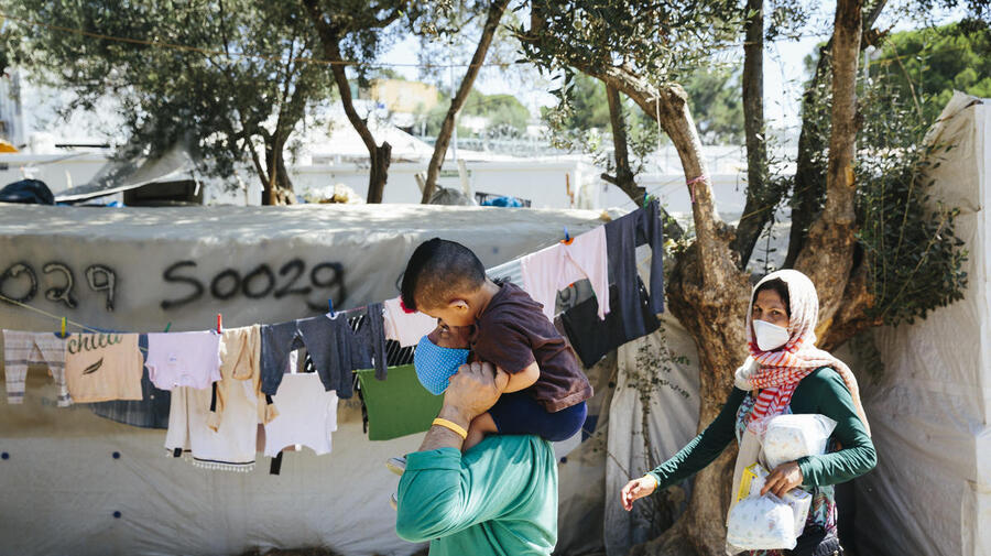 An Aghan refugee family walks through an informal camp outside the Moria Reception and Identification centre on the island of Lesbos, September 1, 2020.

