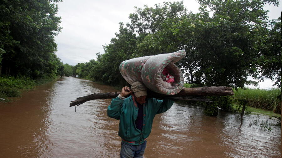 Honduras. Man carries his belongings through a flooded road after the passing of Storm Iota, in Marcovia