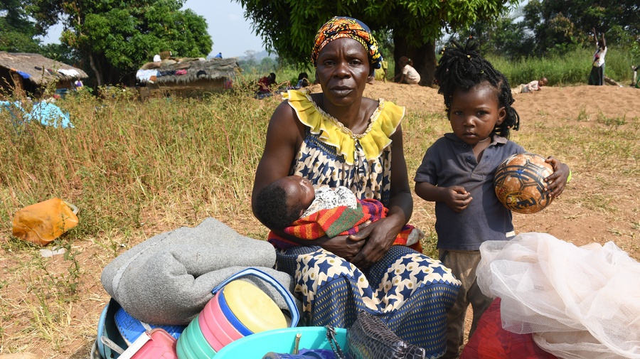 "We fled fearing that rebel groups would come and take over our town. We left everything behind and took a dugout canoe to cross the Ubangi river. We do not have food or a bed, but my daughter is constructing a shelter not far from here."

Yvette, 57, sits with two of her children in Ndu village in the Democratic Republic of the Congo (DRC) after fleeing Bangassou in the Central African Republic. It is the second time she has fled her country as a refugee – after escaping violence in 2017.