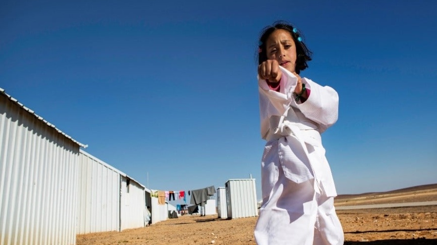 A young girl practices karate moves.