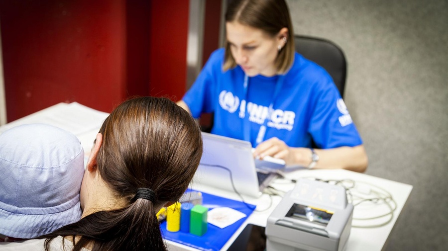 UNHCR worker registers an Ukrainian family on a computer