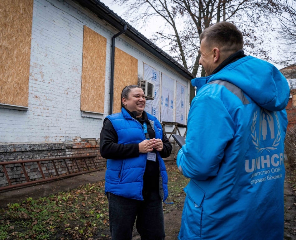 People are standing in front of the damaged building